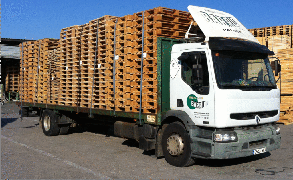 Trincaje de cargas en camión con palets de madera asegurados para transporte industrial