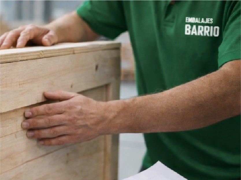 Operario de Embalajes Barrio revisando un embalaje industrial de madera a medida